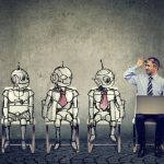 Man sits next to 3 robots
